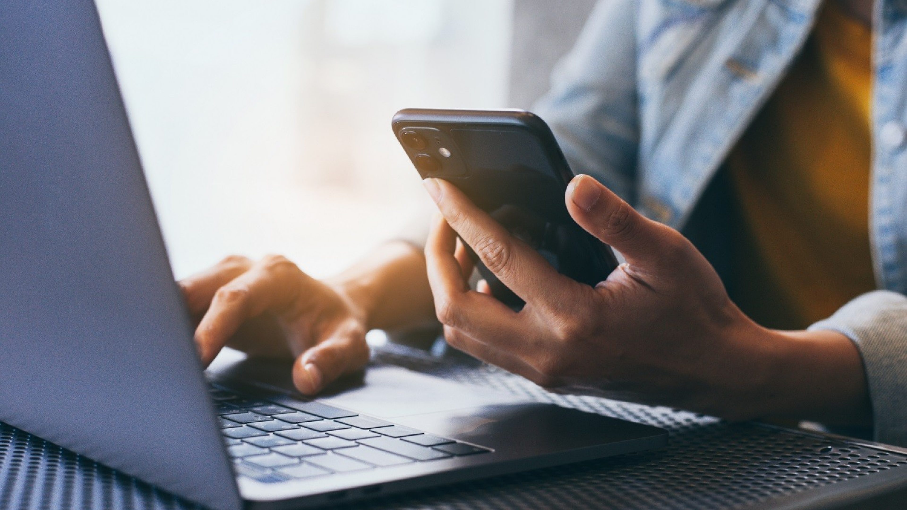 A woman holding a mobile phone and typing